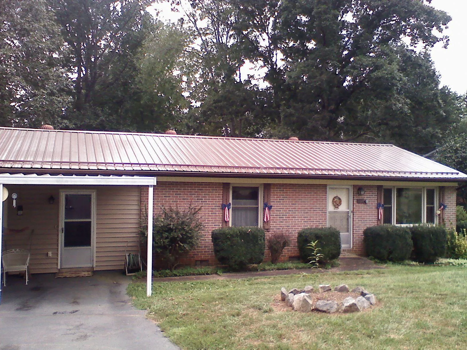 Bronze metal roof and carport on a brick ranch home — Roof Repair work by our crew in Hicksville